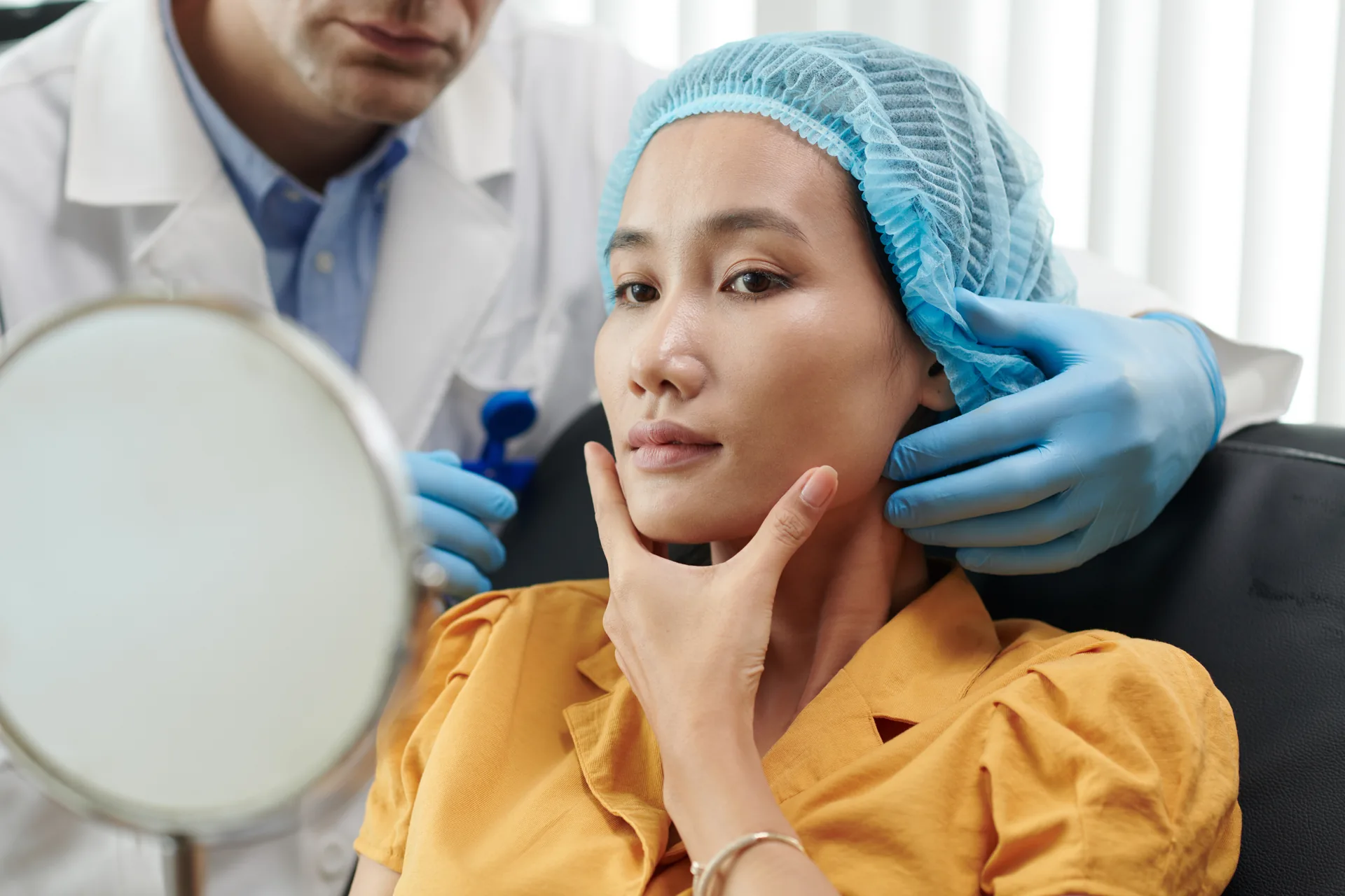 Patient examining her skin in a mirror during a dermatology consultation at Sycamore Dermatology Group